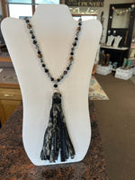 long mixed black beaded necklace with glittery tassel pendant